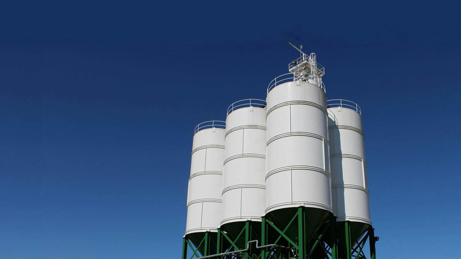 A white APPCO Frac Site Sand Silo Proppant against a blue sky