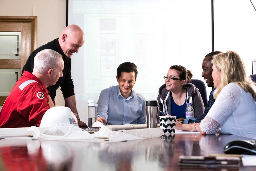 NOV employees gather around a conference table