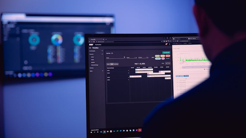 Person looking at data on two screens in a dimly lit room