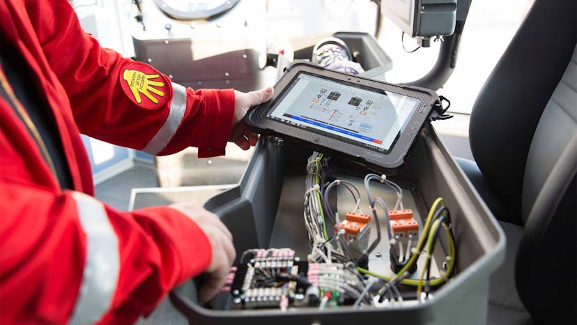 A technician runs software on a tablet connected to a piece of equipment