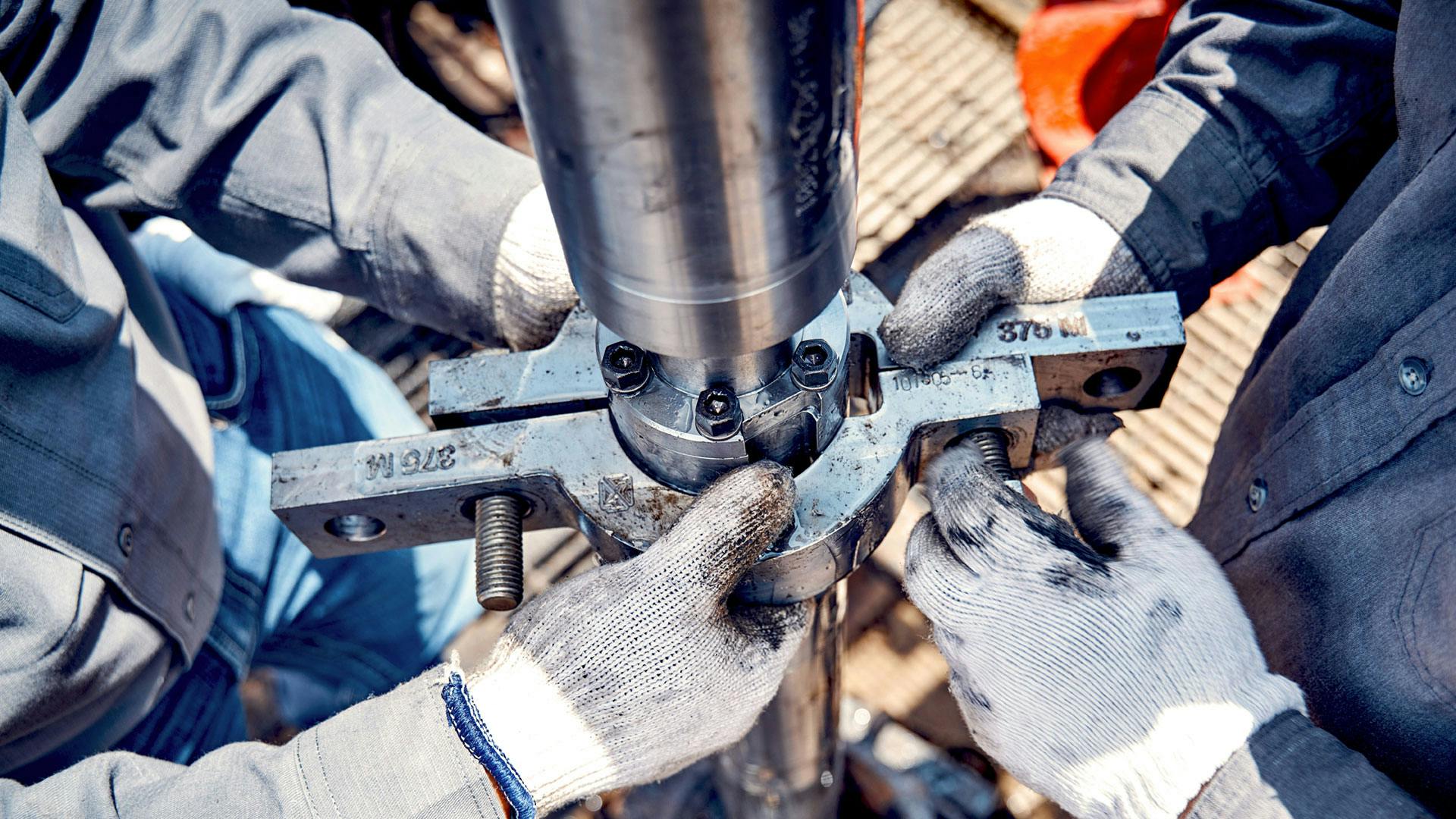 In focus Electronic Submersible Pump (ESP) seal section to motor connection with 375 clamp being put on during system installation. 