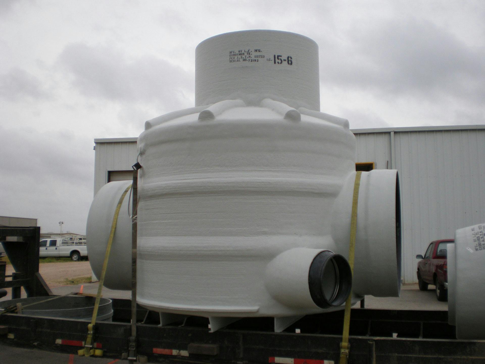 Fiberglass tank accessory strapped on bed of a truck