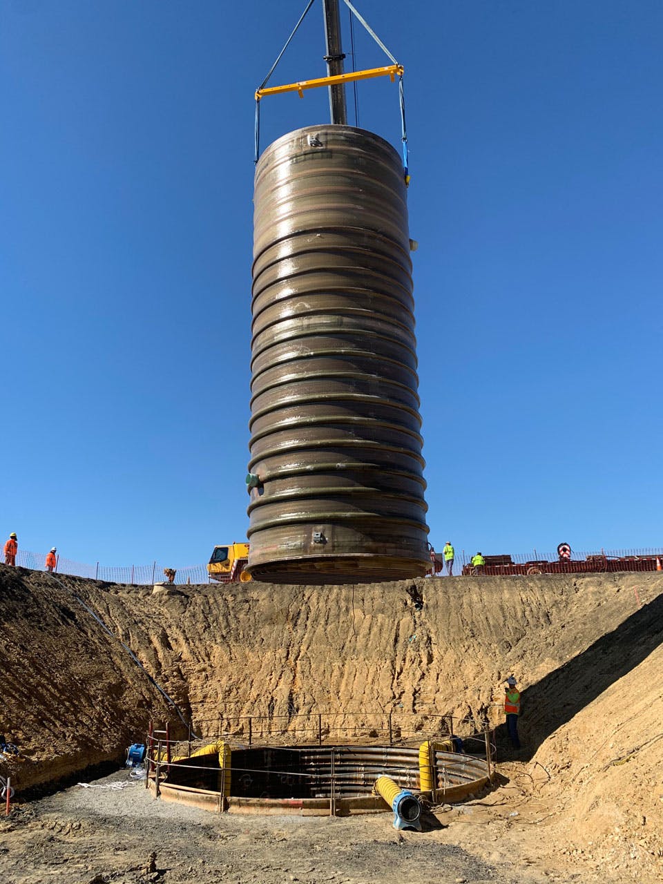 Installation of an FRP structure in a deep pit, with a crew in the background