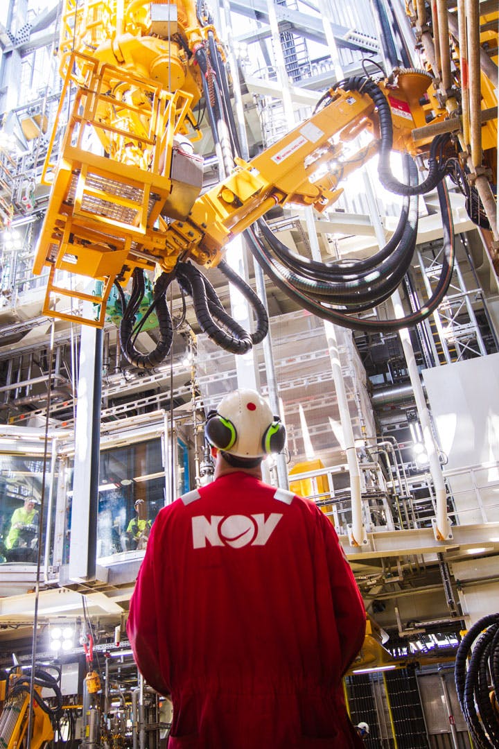 NOV employee wearing red coveralls and white hard hat