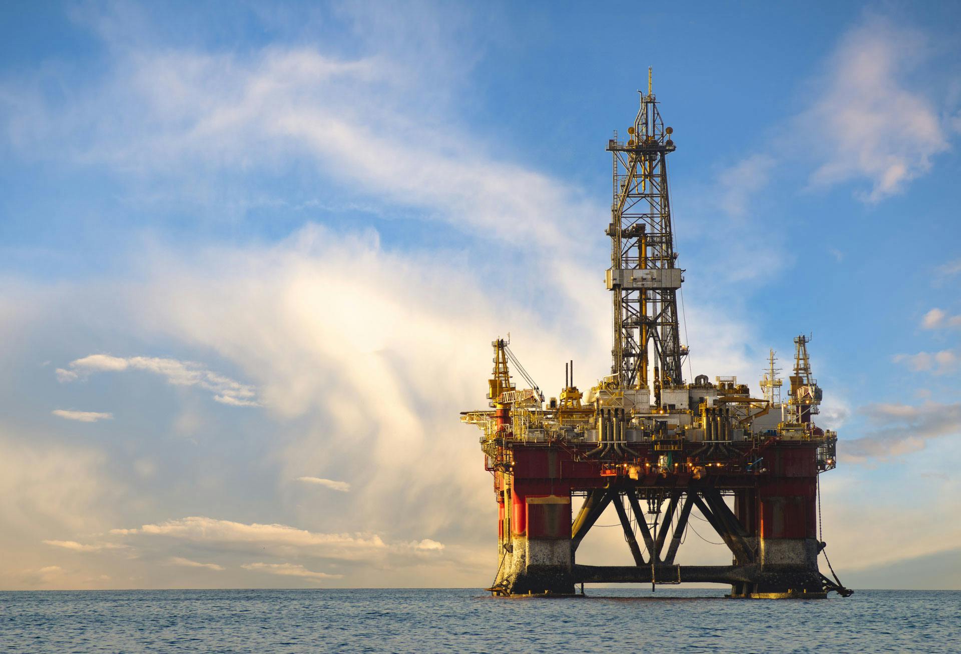 Offshore rig on a calm day with blue sky and light clouds in the background